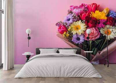 A vibrant bouquet of flowers, including roses, daisies, and tulips, arranged in a brown paper wrapper against a soft pink background. Wall mural