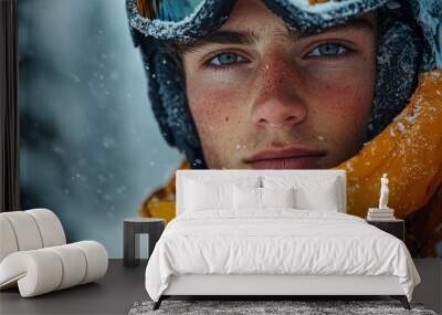 A young man with blue eyes and freckles stares intensely through the falling snow. Wall mural