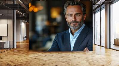 Confident businessman with a beard smiles in a cafe. Wall mural