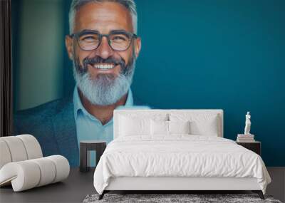 Smiling man in glasses looking at his phone. Wall mural