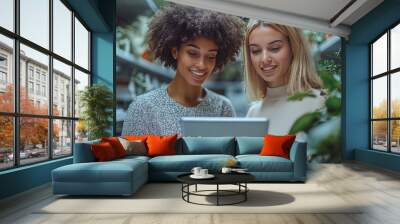 Two women looking at a tablet in a plant store. Wall mural