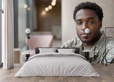 Young African-American man in military uniform looks intently at the camera. Wall mural