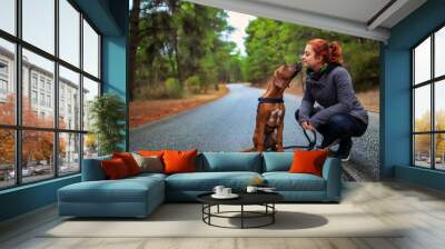 Portrait of happy teenage girl and Rhodesian ridgeback dog . Dog giving girl sweet kiss lick. Love animals love my pet Wall mural