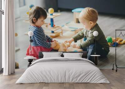 little girl and boy playing with toys by the home Wall mural