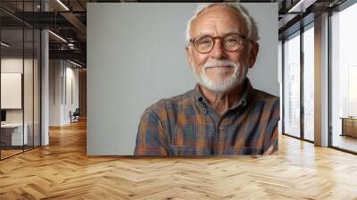 joyful elderly man with a warm smile arms crossed confidently dressed in casual attire isolated against a bright white background radiating positivity and wisdom Wall mural