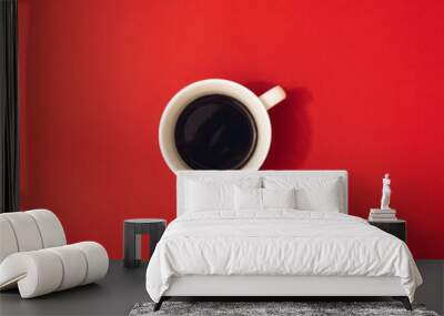 Striking cup of black coffee on red background. Minimal flat lay. Wall mural