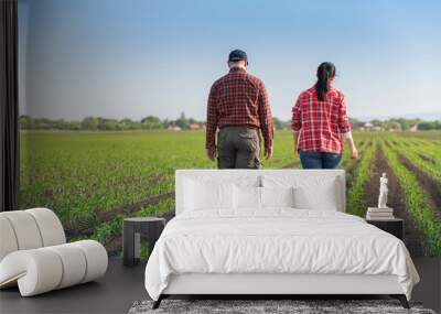 Young farmers examing planted young corn Wall mural