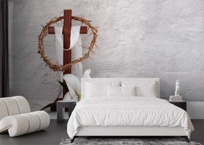 Composition with crown of thorns, wooden cross and lily on light background Wall mural