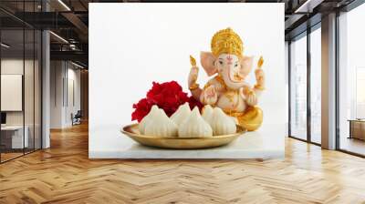 idol of lord ganesha with modak sweet dish and flower. ganesh chaturthi Wall mural