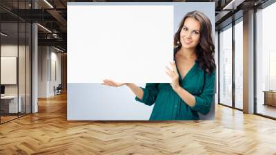 Beautiful young woman showing blank signboard Wall mural