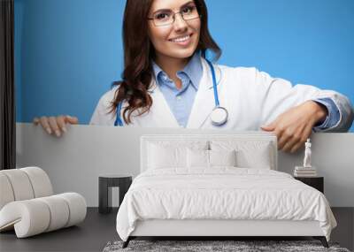 female doctor showing blank signboard, over blue Wall mural