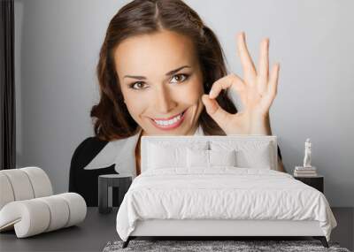 Happy business woman with okay gesture, over grey Wall mural