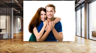 Smiling attractive young amorous couple. Studio portrait image of embracing models at happy in love studio concept, isolated over white background. Man and woman posing together. Wall mural