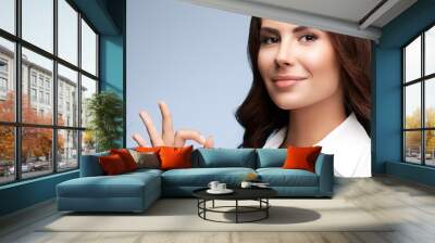 smiling young cheerful businesswoman, showing okay hand sign ges Wall mural