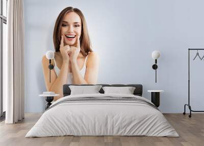 young woman showing smile, on grey Wall mural