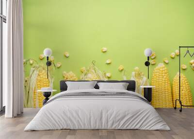 Ripe ears of corn on a green background, space for text. Flat lay. Wall mural