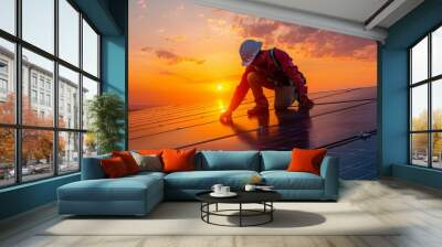 anonymous male worker in protective helmet and uniform working on roof with solar panels against sunset sky Wall mural