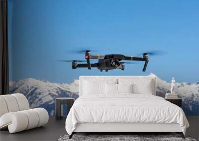 Drone hovering on the background of snow capped mountains. Sochi, Russia. Wall mural