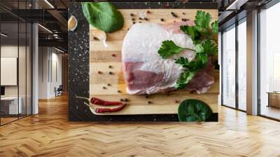 greens, seasonings and meat on a cutting board. a piece of pork, pepper, garlic, salt. Cook at home. fresh food Wall mural