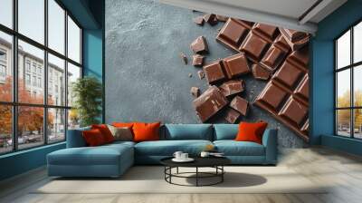 Pieces of tasty chocolate bars on grey table, space for text Wall mural