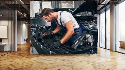 Automobile mechanic using drill on car part Wall mural