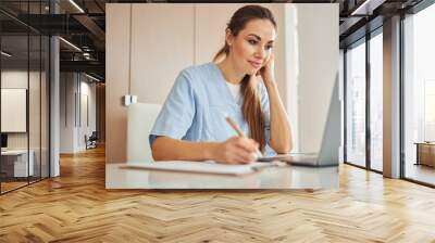 Beautiful female doctor working on her laptop Wall mural