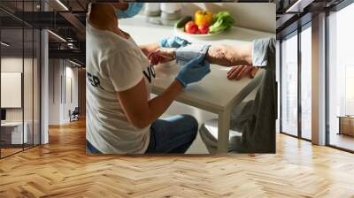 Caregiver measuring the senior woman blood tension Wall mural