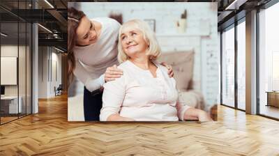 Cheerful woman taking care of her grandmother in wheelchair Wall mural