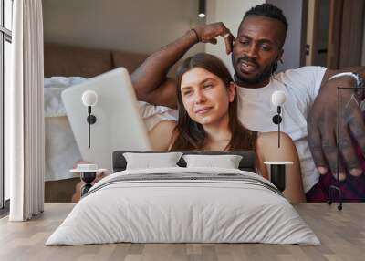 Concentrated female and man watching something on gadget Wall mural