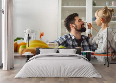 Cute little girl painting on nose of her smiling father Wall mural