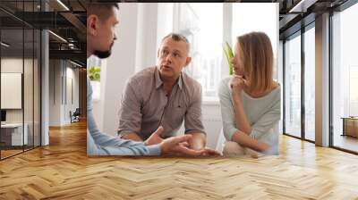 Handsome man talking to his colleagues Wall mural