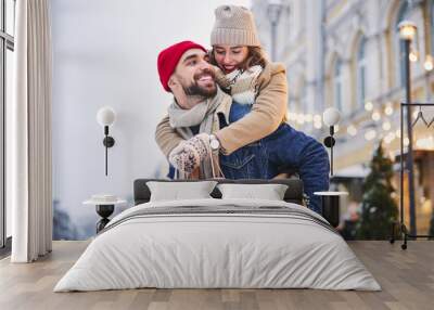 Happy young couple going shopping in winter Wall mural