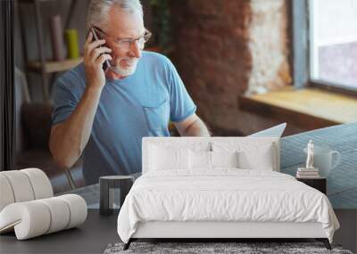 Joyful elderly man talking on phone Wall mural