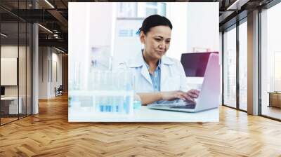 Joyful positive woman sitting in front of the laptop Wall mural