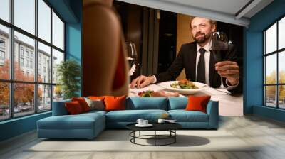 Middle-aged man makes a toast at dinner in a restaurant Wall mural