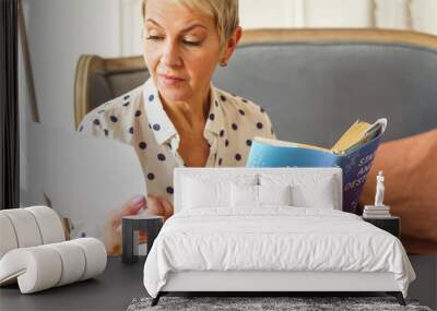 Pleasant blonde woman holding an astrology book Wall mural