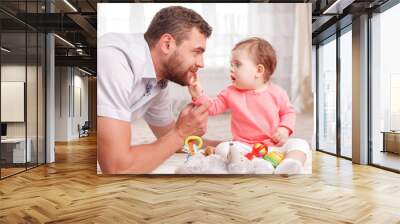 Pleasant young father playing with his child Wall mural