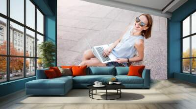 Pretty young woman using a laptop Wall mural