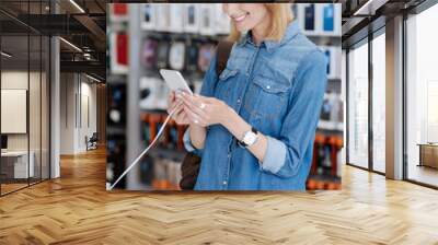 Radiant woman testing mockup smartphone at store Wall mural