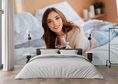 Relaxed girl enjoying glass of wine while resting at home Wall mural