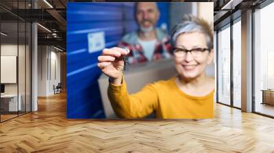 Smiling lady holding keys to storage room Wall mural