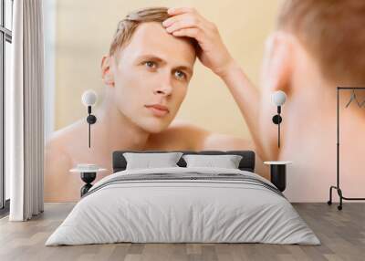 Topless man fixing hair in front of mirror Wall mural