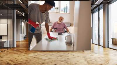 Young man doing the cleaning in the kitchen Wall mural