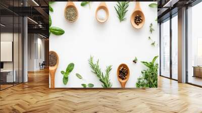 Fresh herbal ingredients in wooden spoons on white background Wall mural