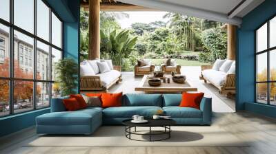 A minimalist open-air living room with bamboo furniture, soft neutral textiles, and a garden backdrop of tropical plants and trees Wall mural