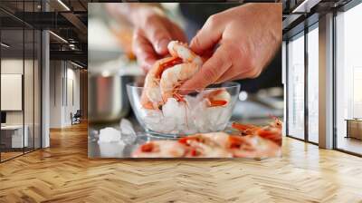 hands peeling and deveining shrimp, with a bowl of ice and fresh seafood arranged on a clean, stainless steel countertop in a professional kitchen Wall mural