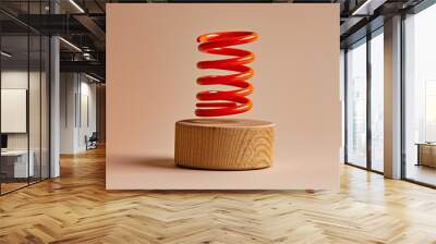 a twisty red spring toy on a wooden cylinder on a pale brown background Wall mural