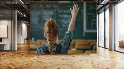 Back view of student raising her hand to answer teachers question during education training class. Wall mural