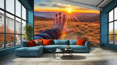 Young man hand reaching for the mountains during sunrise and beautiful landscape Wall mural