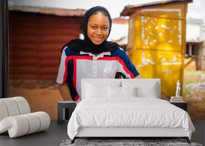 beautiful african professional carpenter smiling as she takes measurement of wood Wall mural